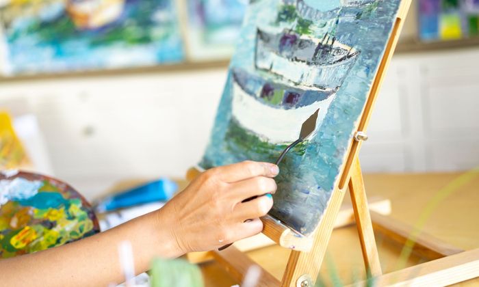 hand working on a painting of a sailboat