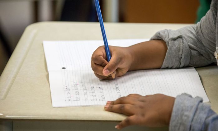 child writing at a desk