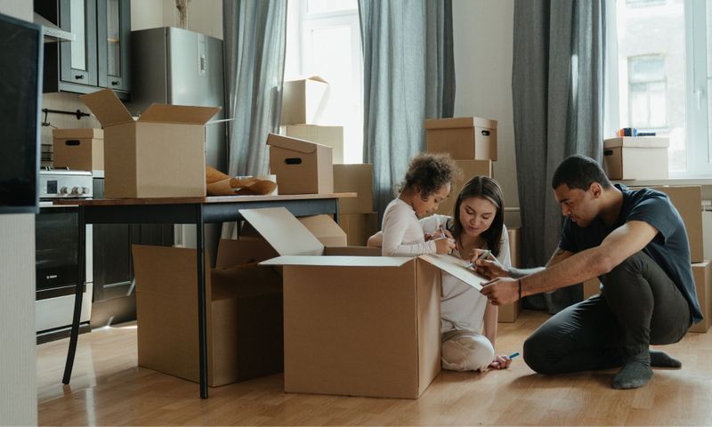 young family with moving boxes in new house