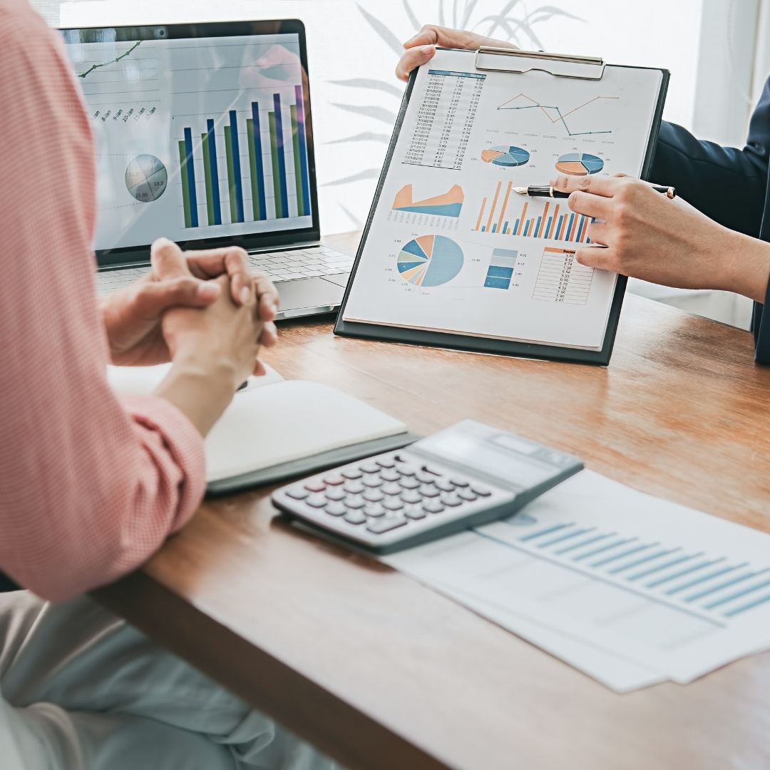 A financial advisor pointing to charts and graphs, explaining financial options to a client.
