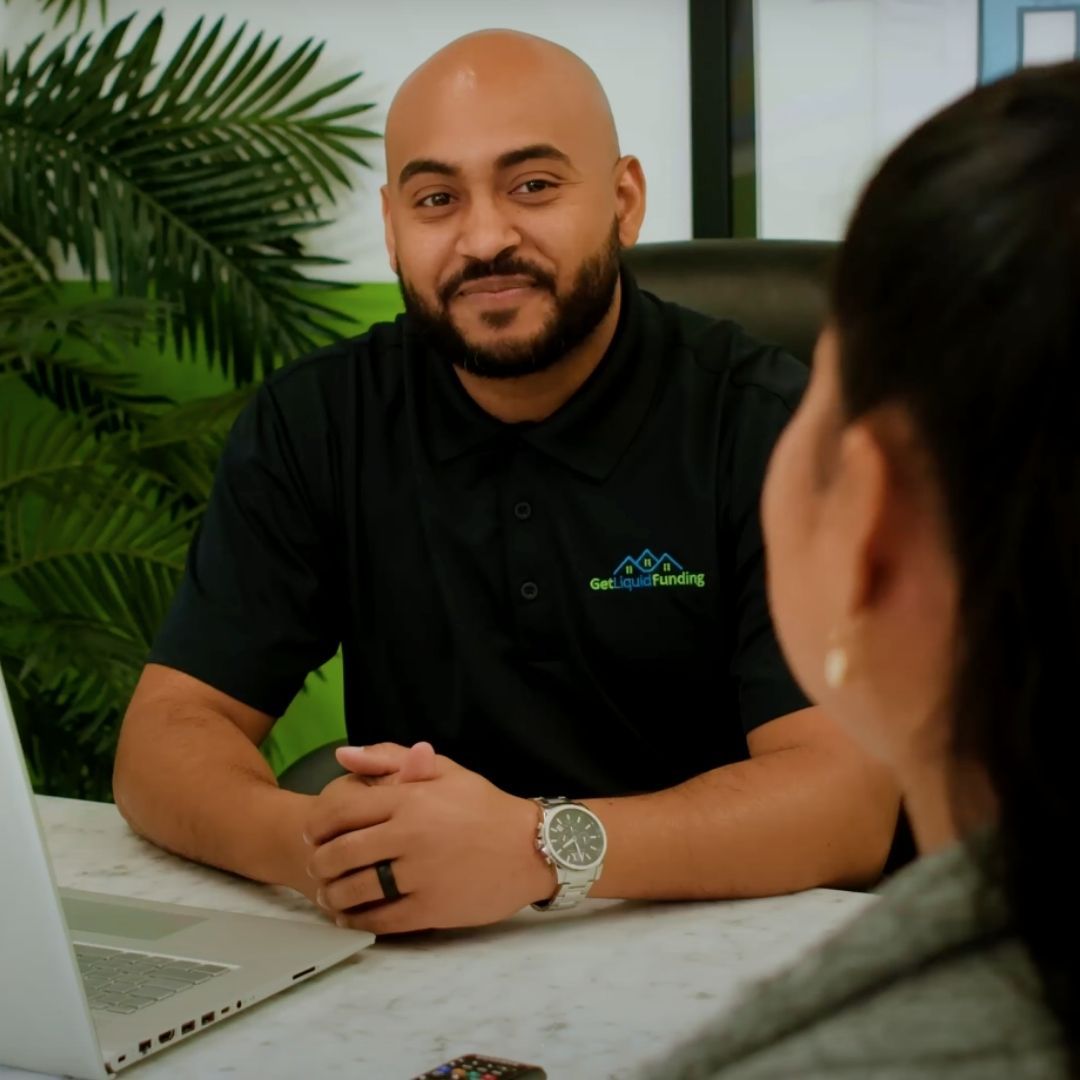 A Get Liquid Funding representative smiling and talking with a client during a consultation.