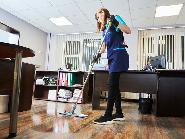 A woman cleaning an office floor