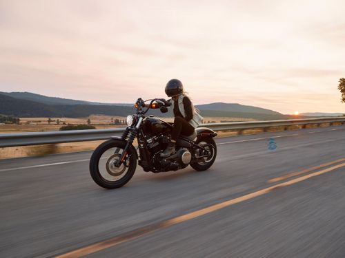 woman riding motorcycle with mountains in the background