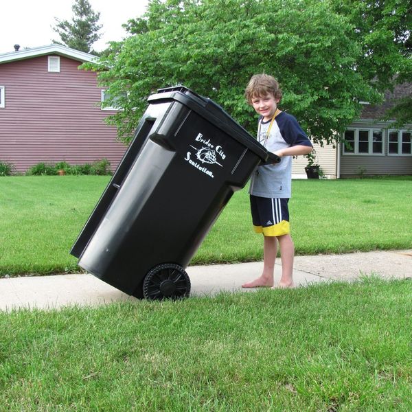 a young boy taking out a trashcan Guide to a Strong Rodent Perimeter Defense (4).jpg
