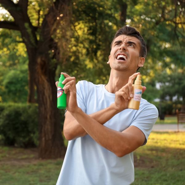 Man spraying bug repellant in both hands