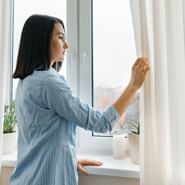 a woman looking out of a window What to Do About a Snake in Your Yard (2).jpg