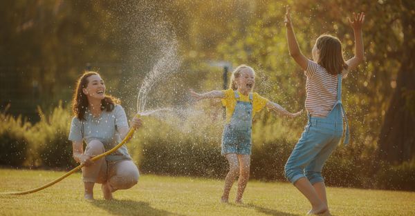 kids paying outside in water hose 