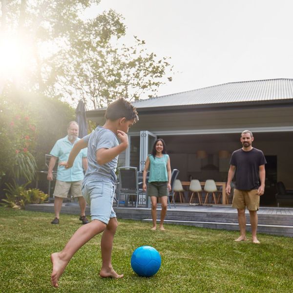 family playing soccer in back yard