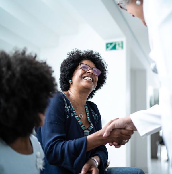 A woman being greeted by a doctor