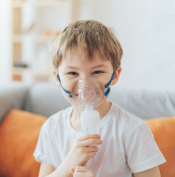 A boy wearing a nebulizer