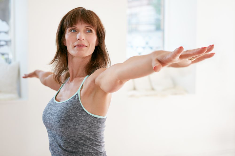 Woman stretching with arms extended, feeling energized after IV vitamin therapy