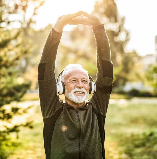 A older man stretching his arms outdoors
