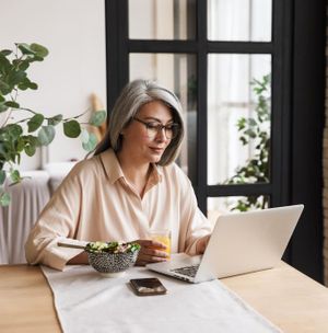 A woman at home looking at her laptop