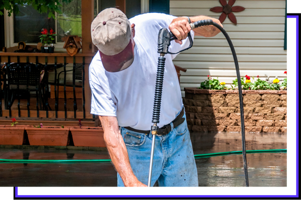 A man pressure washing a property.