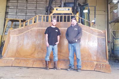 workers sanding in front of big machine