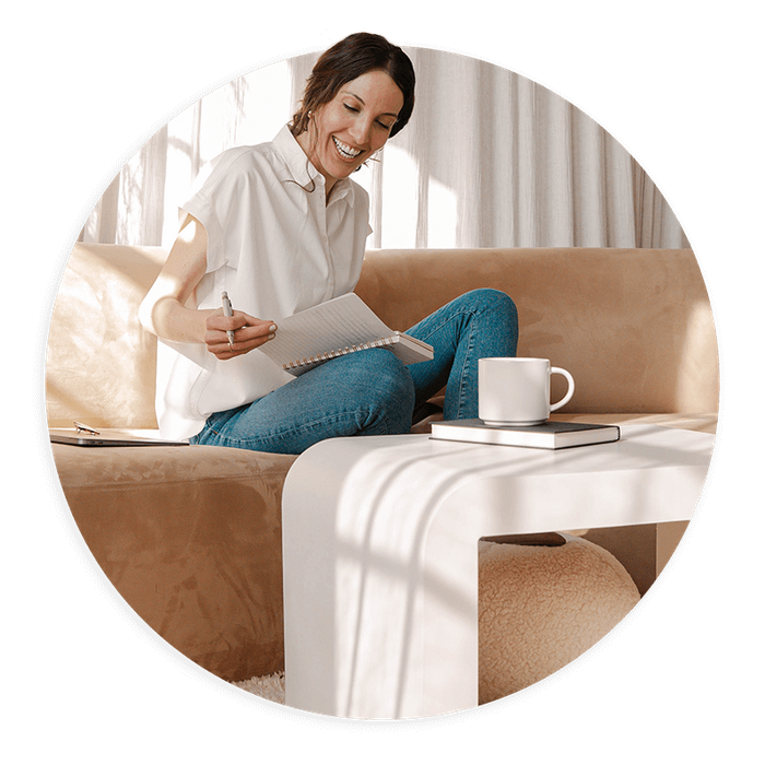 Woman sitting on couch in modern room viewing paperwork