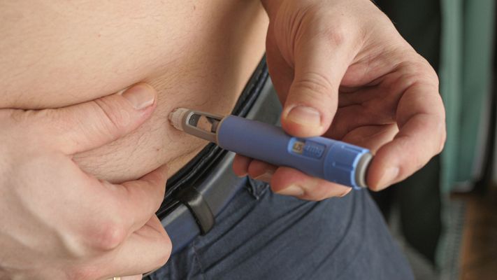 Person injecting semaglutide into their stomach. 