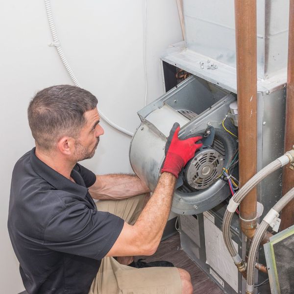 a man replacing a furnace fan The Top Reasons Your Furnace Needs Professional Repair This Winter.jpg