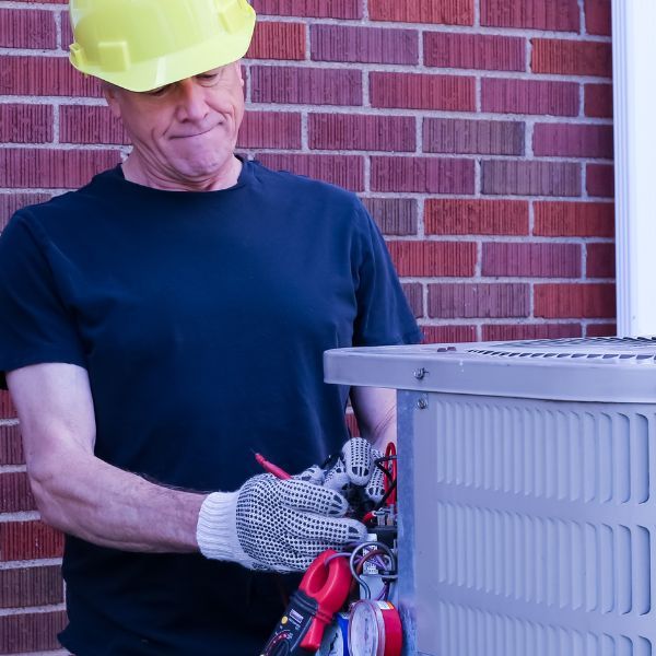 man fixing HVAC unit man fixing HVAC unit