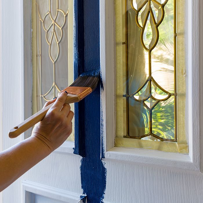 brushing blue paint onto door