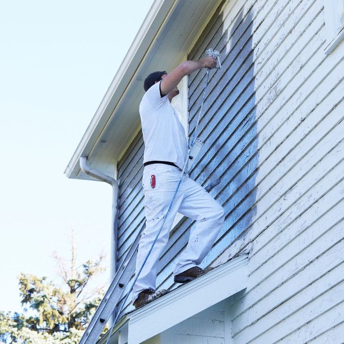 A painter painting the outside of a home