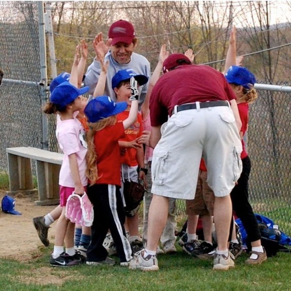 Children and coaches high fiving