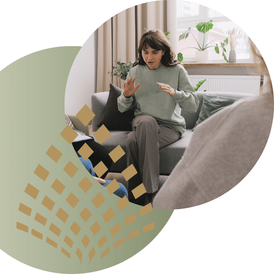 A small group therapy session, with people sitting in a circle and engaging with a therapist.