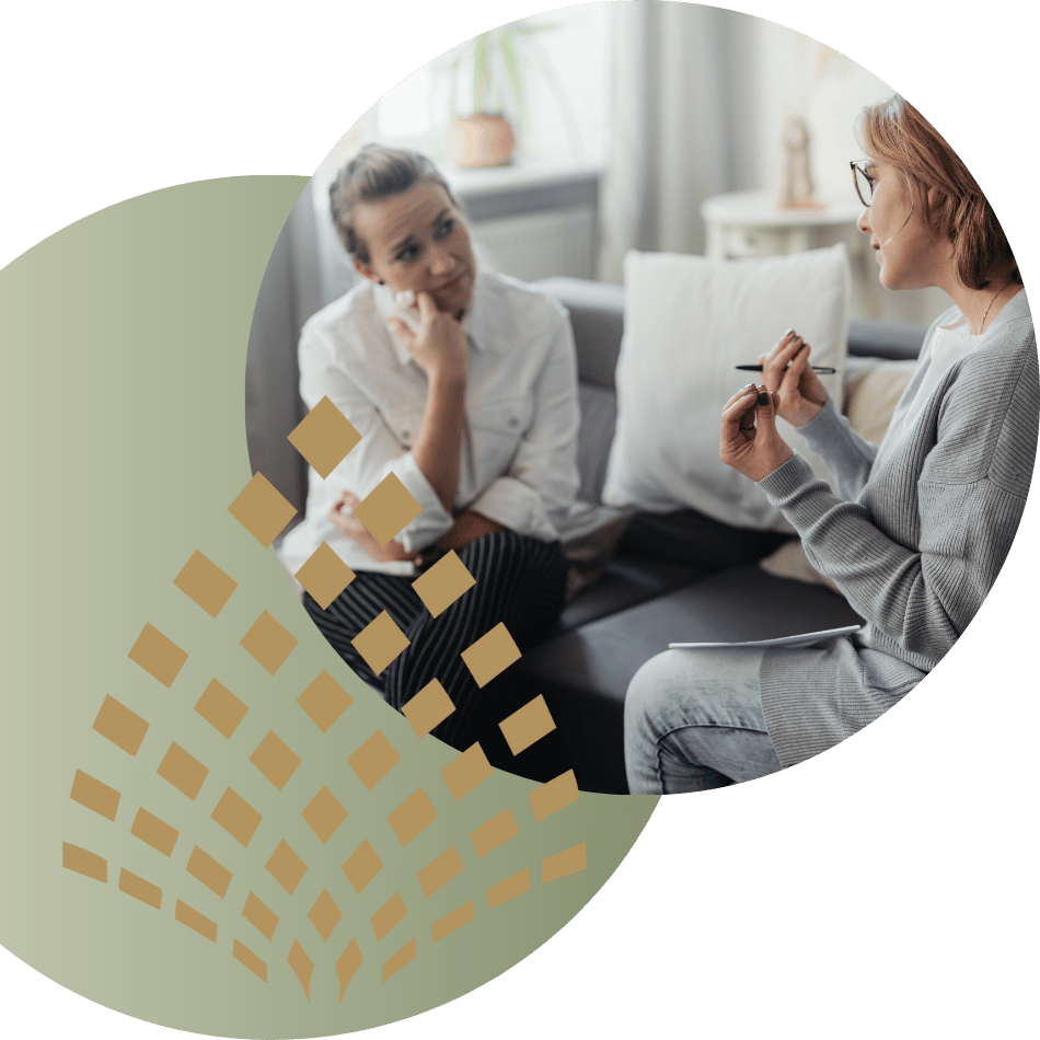 A distressed woman sitting on a couch, holding her head, representing depression therapy.