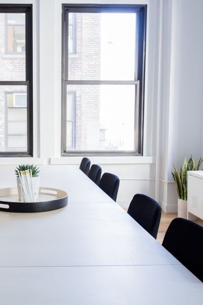 clean modern office with white table and black chairs
