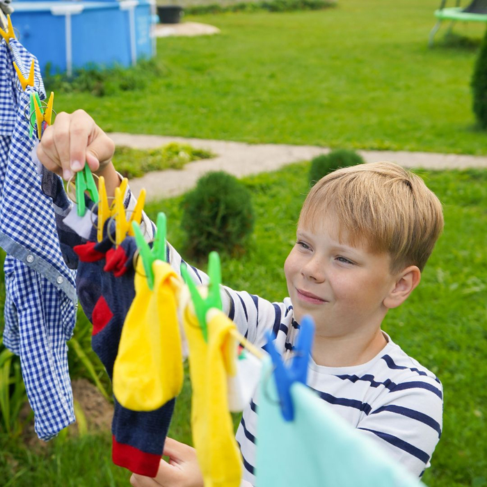 young child hanging clothes on line