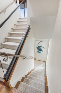 A bright, open modern residential staircase featuring light-filled multi-level design, structural glass guardrails, and sleek minimalist Componance architectural handrails. Componance Modern Glass and Wall Mounted Handrail System