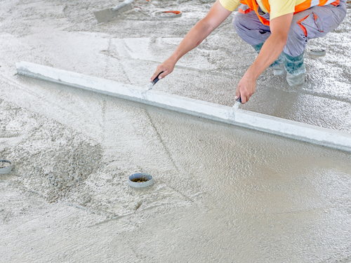 a worker laying down new concrete