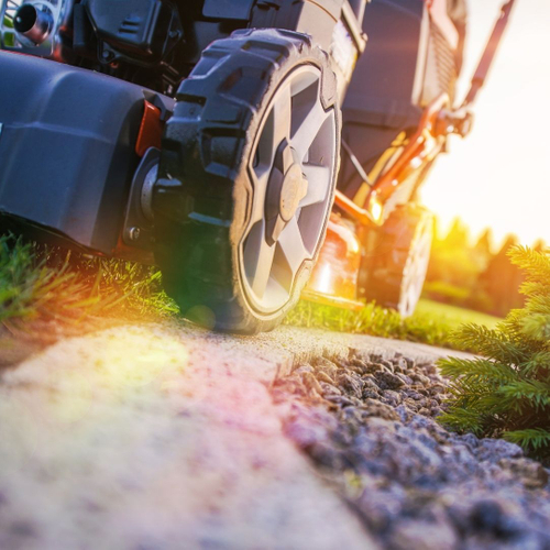 lawn being mowed around landscaped area