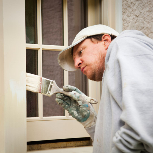 Man painting the exterior of a building. 