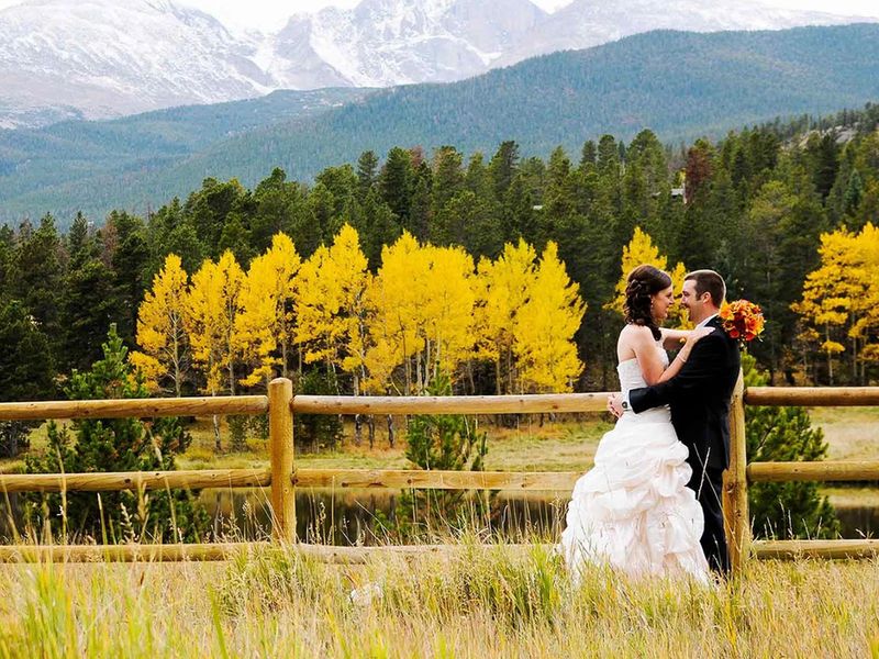 image of a couple in front of yellow aspens in fall