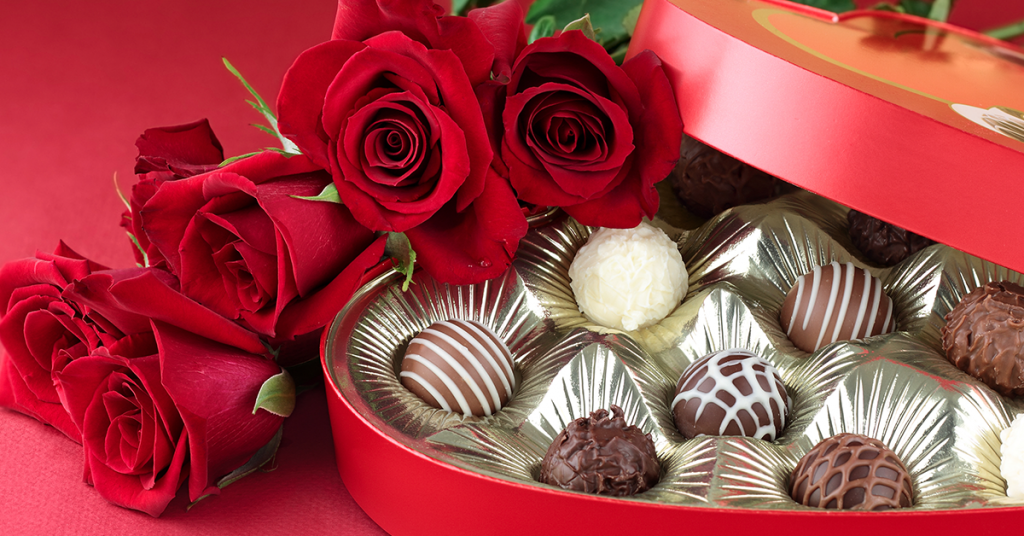 An open box of chocolates and roses