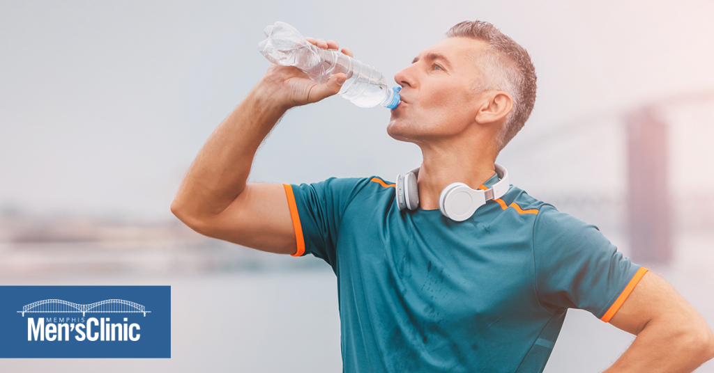 an athletic man taking a break drinking water