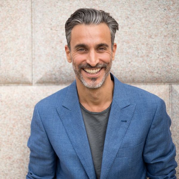 Man wearing blue suit jacket smiling