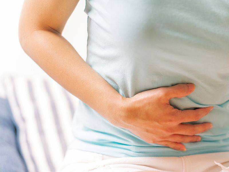 A woman experiences stomach pain.