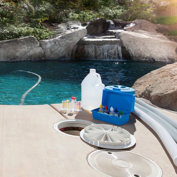 cleaning supplies sitting next to a pool with a water feature