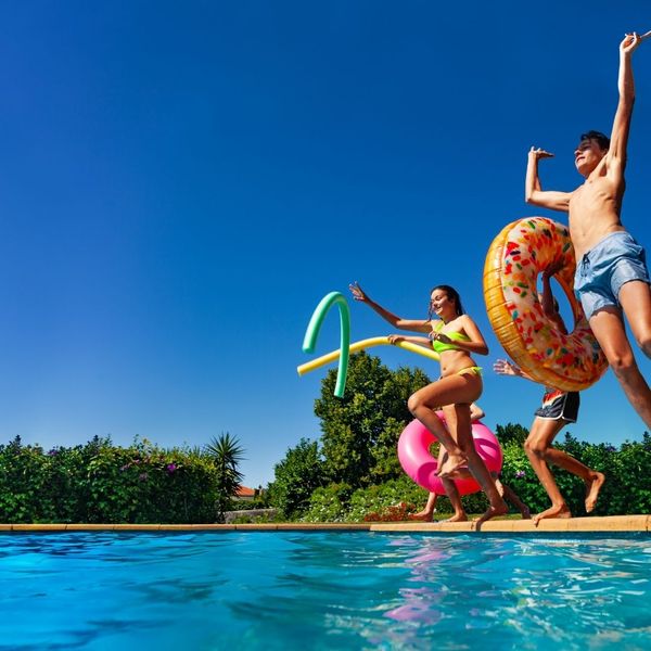 kids with floaties jumping into a pool