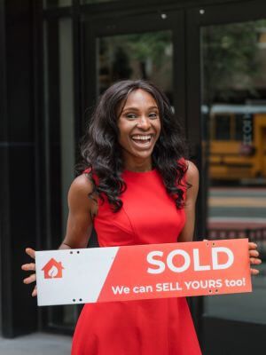 real estate agent holding "sold" sign