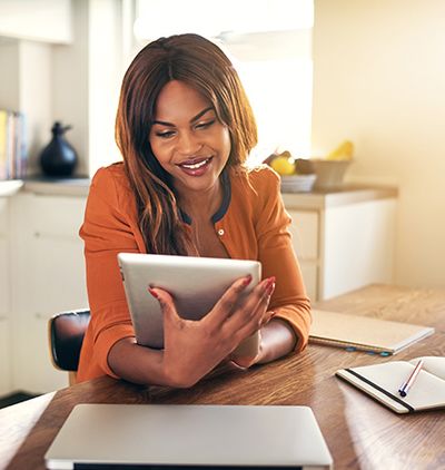 Image of woman smiling at a tablet