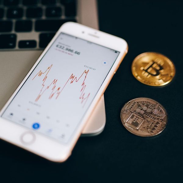 close up shot of phone and bitcoins