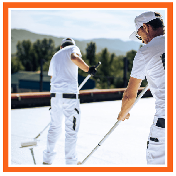 commercial roofers applying a coating to a flat roof