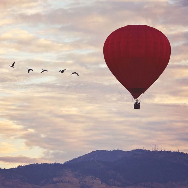 Single air balloon floating above a mountain