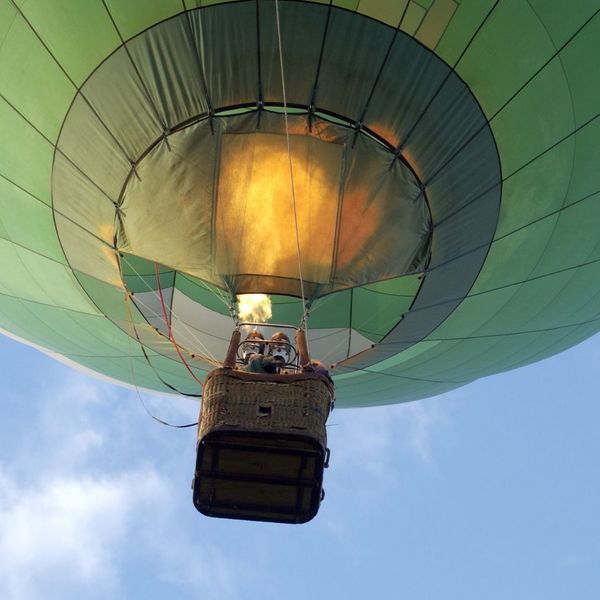 a green hot air balloon rising into the sky