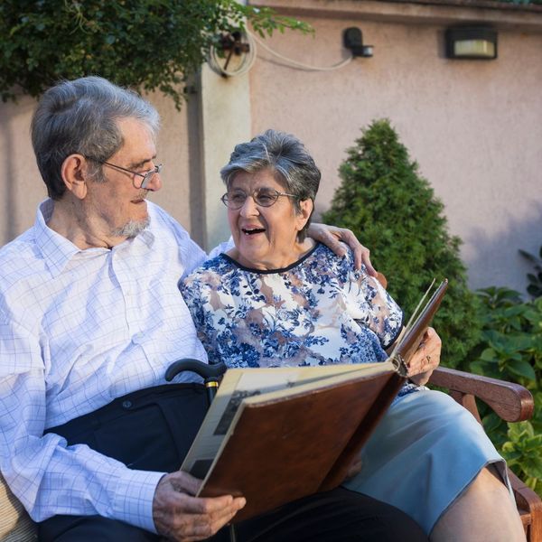 an elderly couple looking at a picture book