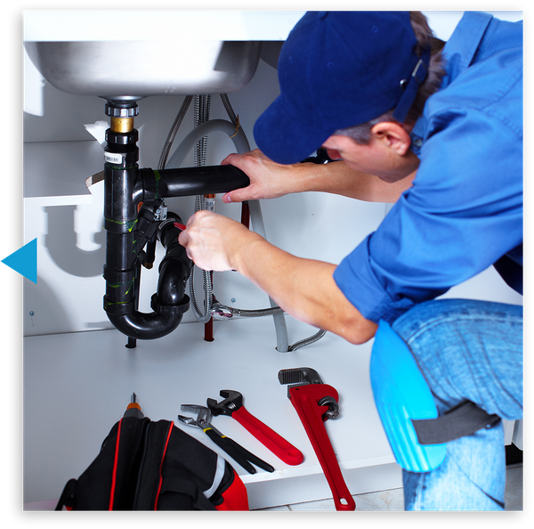 Plumber working on pipes under a sink