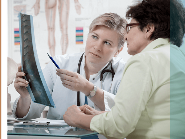 a chiropractor and a client looking at a spine x-ray